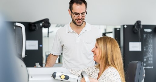 Ein Physiotherapeut befindet sich mit einer Patientin im Trainingsraum 