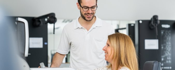 Ein Physiotherapeut befindet sich mit einer Patientin im Trainingsraum