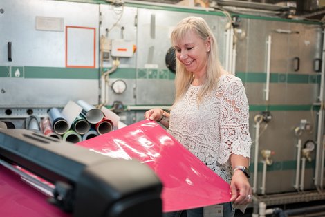 Sylvia Hollnsteiner bei der Arbeit mit einem Laminiergerät