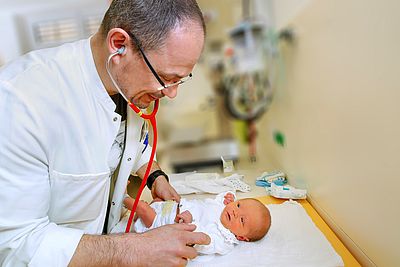 Arzt untersucht Neugeborenes