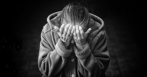 alte Frau legt ihren Kopf in ihre Hände