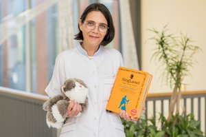 Pflegerin mit Therapiekatze und Musikbuch