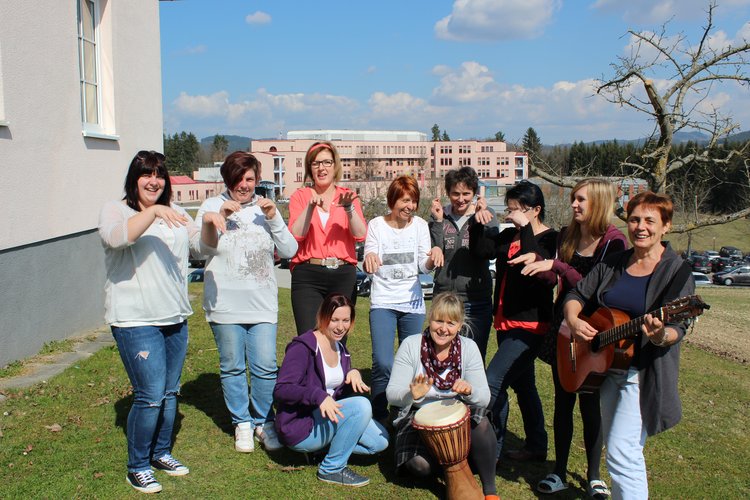 Schülerinnen und Lehrerin beim Singen vor der Schule