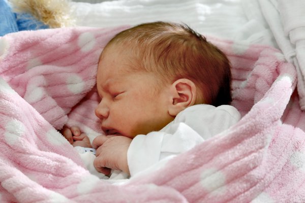 Neugeborenes Baby in rosa Decke gewickelt