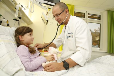 Arzt hört Kind im Krankenbett ab