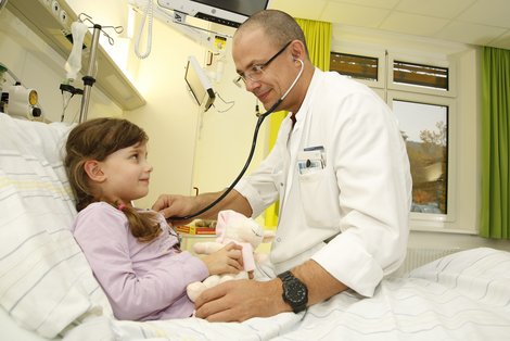 Arzt hört Kind im Krankenbett ab
