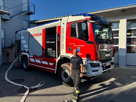 Florian Kirchmayr in Feuerwehrausrüstung vor dem Feuerwehrauto der FF Schärding.