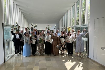 Gruppenfoto der AbsolventInnen mit Rosen und Diplomen