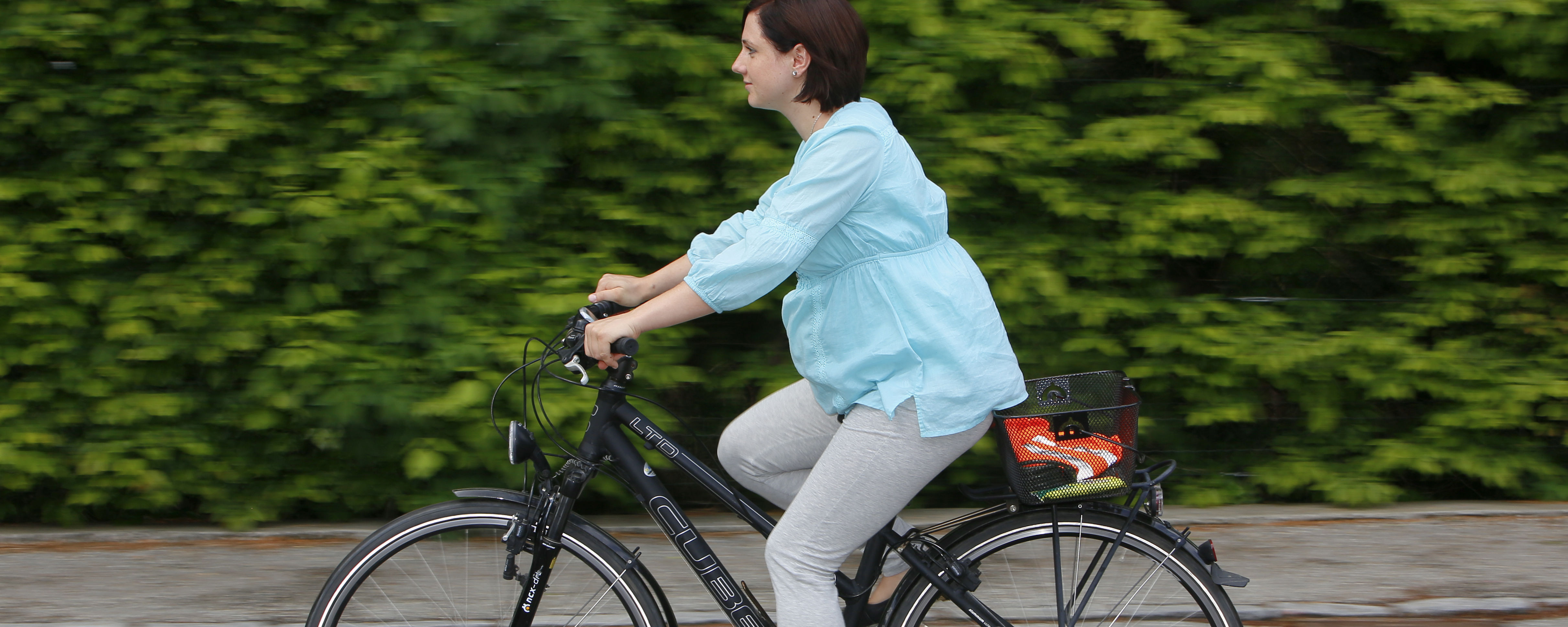 Schwangere Dame fährt auf dem Fahrrad