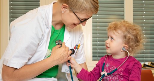 Ärztin spielt mit einem kleinen Mädchen