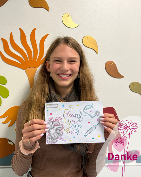 Patientin hält eine Zeichnung mit der Aufschrift "Thank you so much" in die Kamera