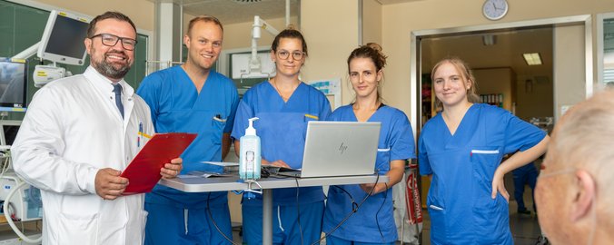 Arzt und Pflegepersonal sprechen mit einem Patienten
