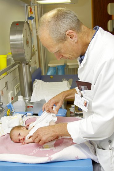 Mitarbeiter untersucht ein Baby nach der Geburt