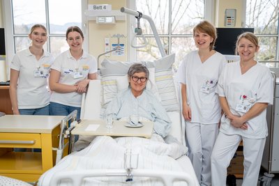 Pflegeschülerinnen stehen um Krankenbett mit Schauspiel-Patientin