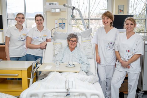 Pflegeschülerinnen stehen um Krankenbett mit Schauspiel-Patientin