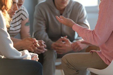 Personen sitzen im Kreis und reden