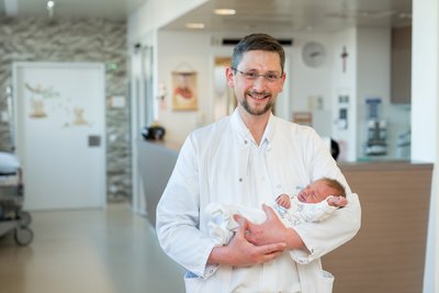 Prim. Degenhart mit Baby im Arm