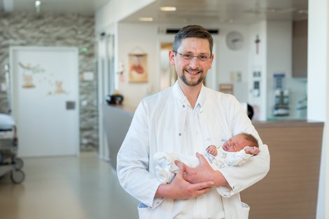 Prim. Degenhart mit Baby im Arm