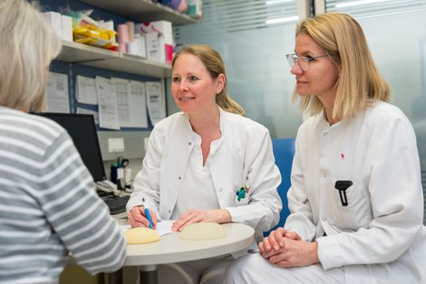 Zwei Chirurginnen sprechen mit einer Patientin