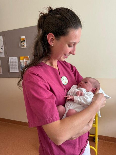 Hebamme Eva-Maria Eckerstorfer mit einem Baby in den Armen