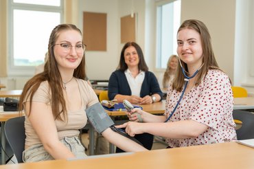 Auszubildende beim Blutdruckmessen