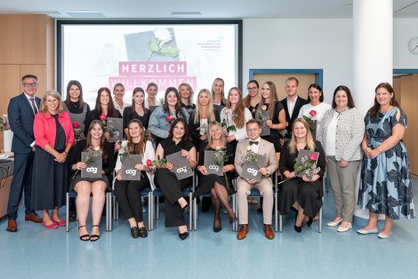 Gruppenbild bei Abschlussfeier - AbsolventInnen halten Rose in der Hand
