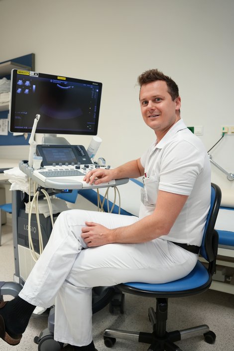 Arzt sitzt vor Untersuchungsgerät