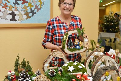 Frau bietet selbstgebastelte Weihnachtsdeko an