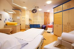 Gebärzimmer. Gebärbett. CTG Gerät. Wärmelampe. Wickelplatz. Waschplatz. Babywaage.  große Lampe. Gebärbadewanne in rosa.
