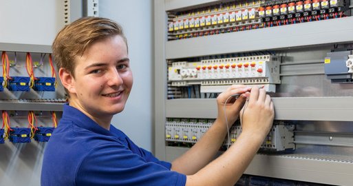 Lehrling arbeitet an einem Elektro-Schaltkasten