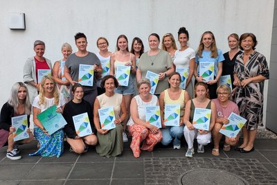 Gruppenfoto der Absolventinnen mit Diplomen in der Hand