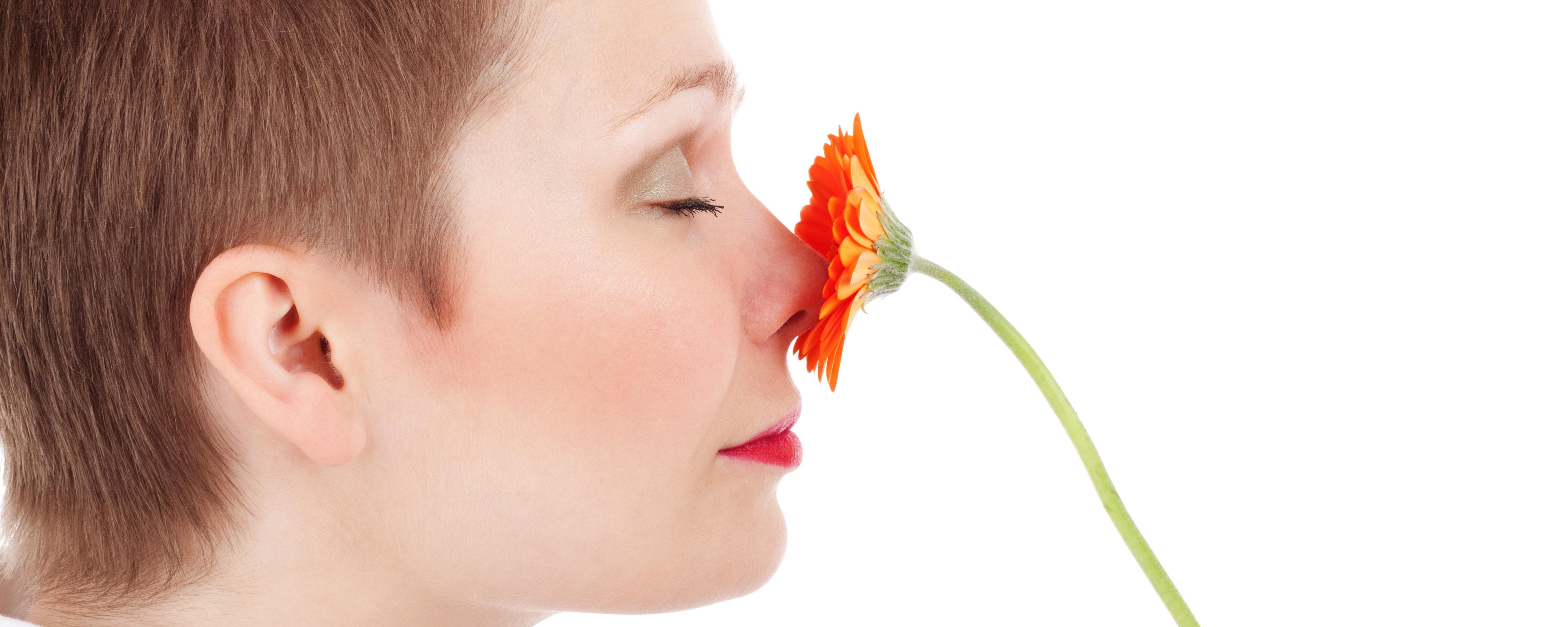 Frau riecht an einer Blume