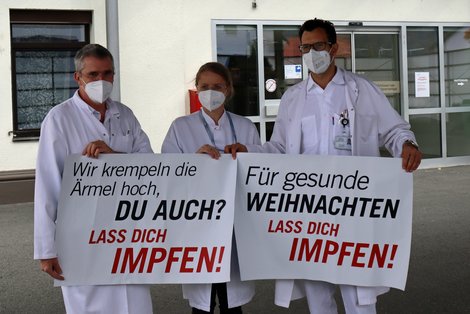 MitarbeiterInnen mit Transparenten vor dem Klinikum