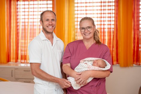 Primar und Hebamme mit Baby am Arm