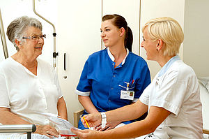 Schülerin und Krankenpflegerin im Gespräch mit einer Patientin