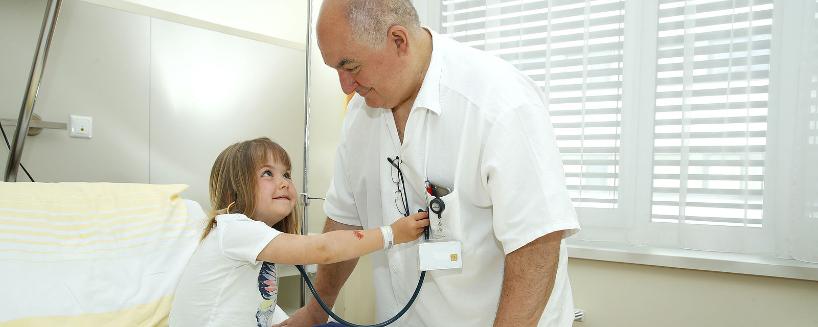Arzt untersucht Kind auf der Kinderstation