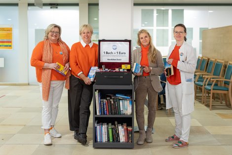 Soroptimistinnen mit Bücherspende und zwei Mitarbeiterinnen