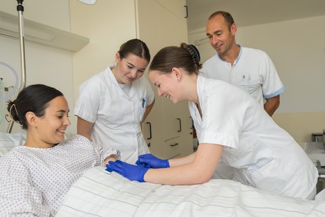 Auszubildende mit Rettenegger beim Üben am Krankenbett