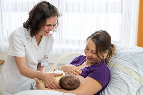 Hebamme Birgit Sölradl bei einer Stillberatung mit einer Patientin und ihrem Baby
