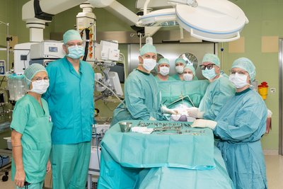 OP-Team steht rund um Instrumententisch im OP