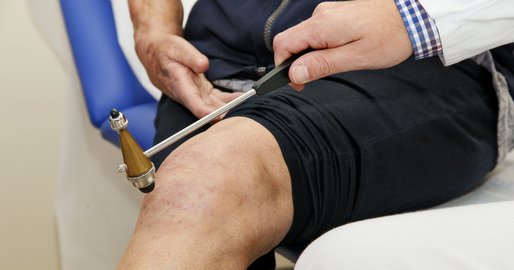 Arzt untersucht Kniescheibe eines Patienten