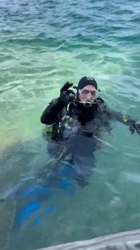 Florian Kirchmayr in Tauchausrüstung im Wasser zeigt OK-Zeichen