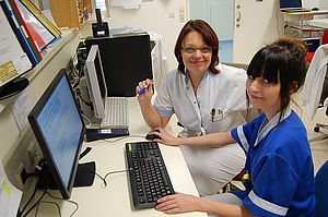 Schülerin mit Krankenpflegerin bei der Arbeit am Computer