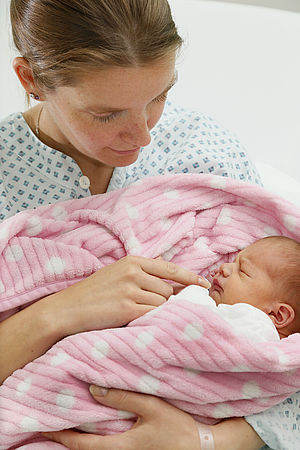 Mutter mit Neugeborenen am Arm