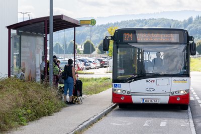 Bushaltestelle vor dem Salzkammergut Klinikum Vöcklabruck mit Bus und wartenden Personen