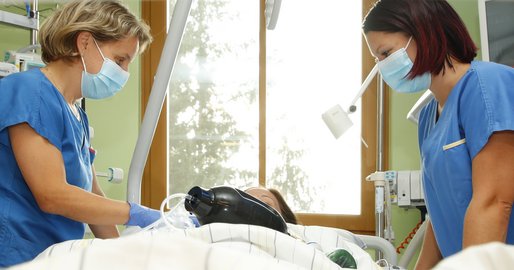 Zwei Mitarbeiterinnen an einem Krankenbett auf der Intensivstation
