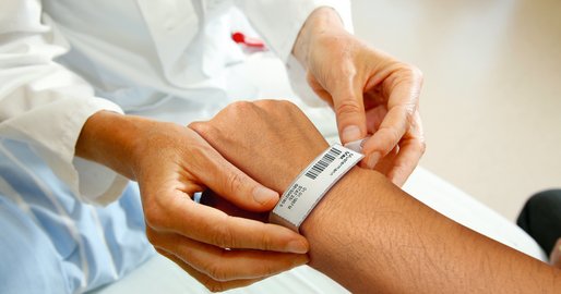 Eine Ärztin bringt ein Patientenarmband an
