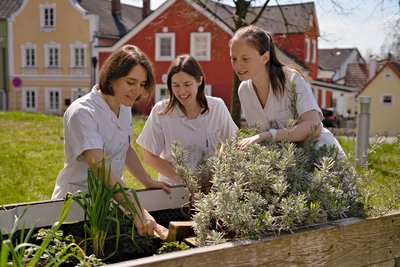 Die Ergotherapeutinnen am Klinikum Schärding: Andrea Himsl, Karina Pflanzl und Susanne Kaiser am Hochbeet des Therapiegartens. 