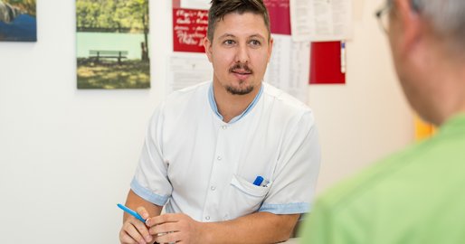 Ein Pfleger führt ein Aufnahmegespräch mit einem Patienten