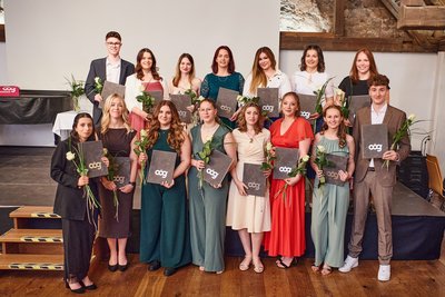 Gruppenfoto, AbsolventInnen halten Diplom und Rose in den Händen